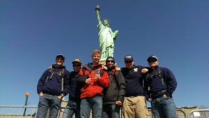 People posing in front of the Statue of Liberty
