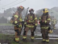 Fire-men having a conversation on the scene of a fire
