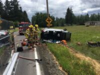 Men standing by overturned vehicle